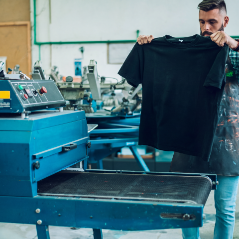 Machine à broder appliquant un logo sur un vêtement corporatif